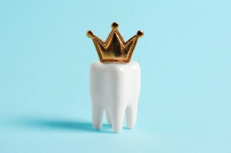 Tooth in the crown on blue background. 